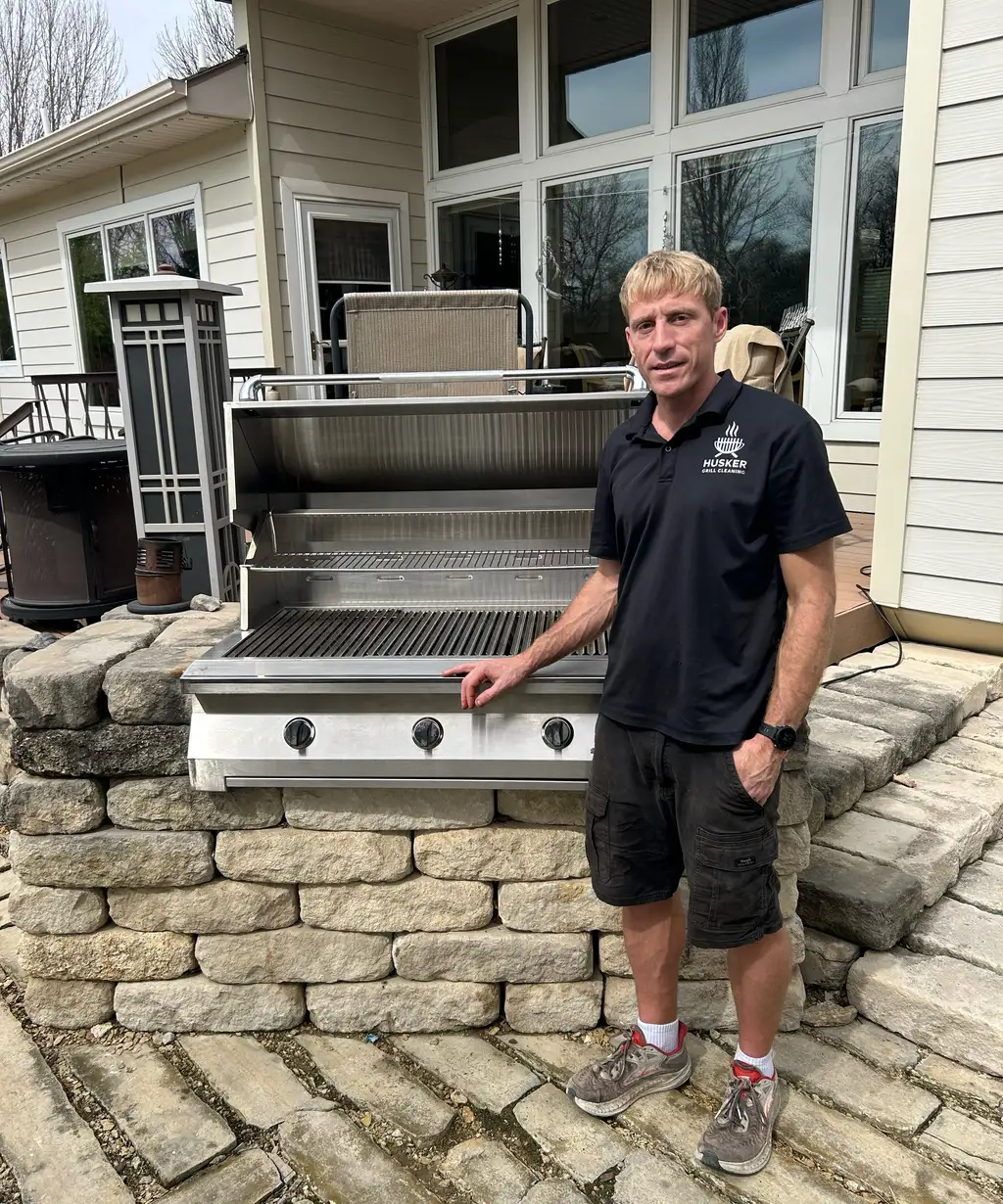 Matthew Brunken standing beside a large stainless steel grill